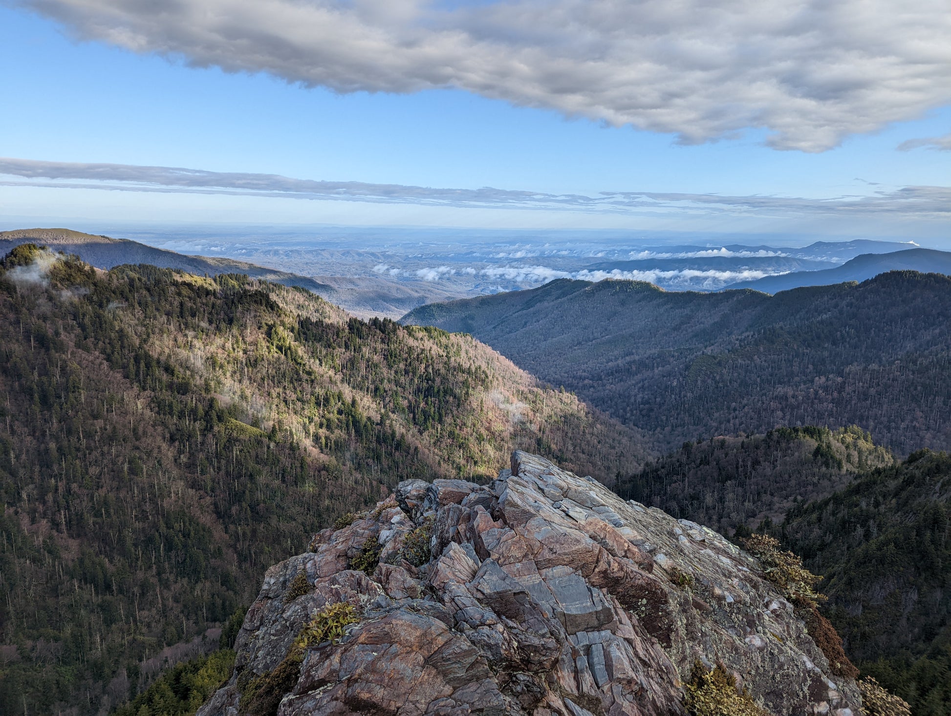 A rocky outcropping with mountain ridges in the background